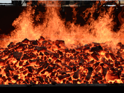Firewood and hot coal in a gr